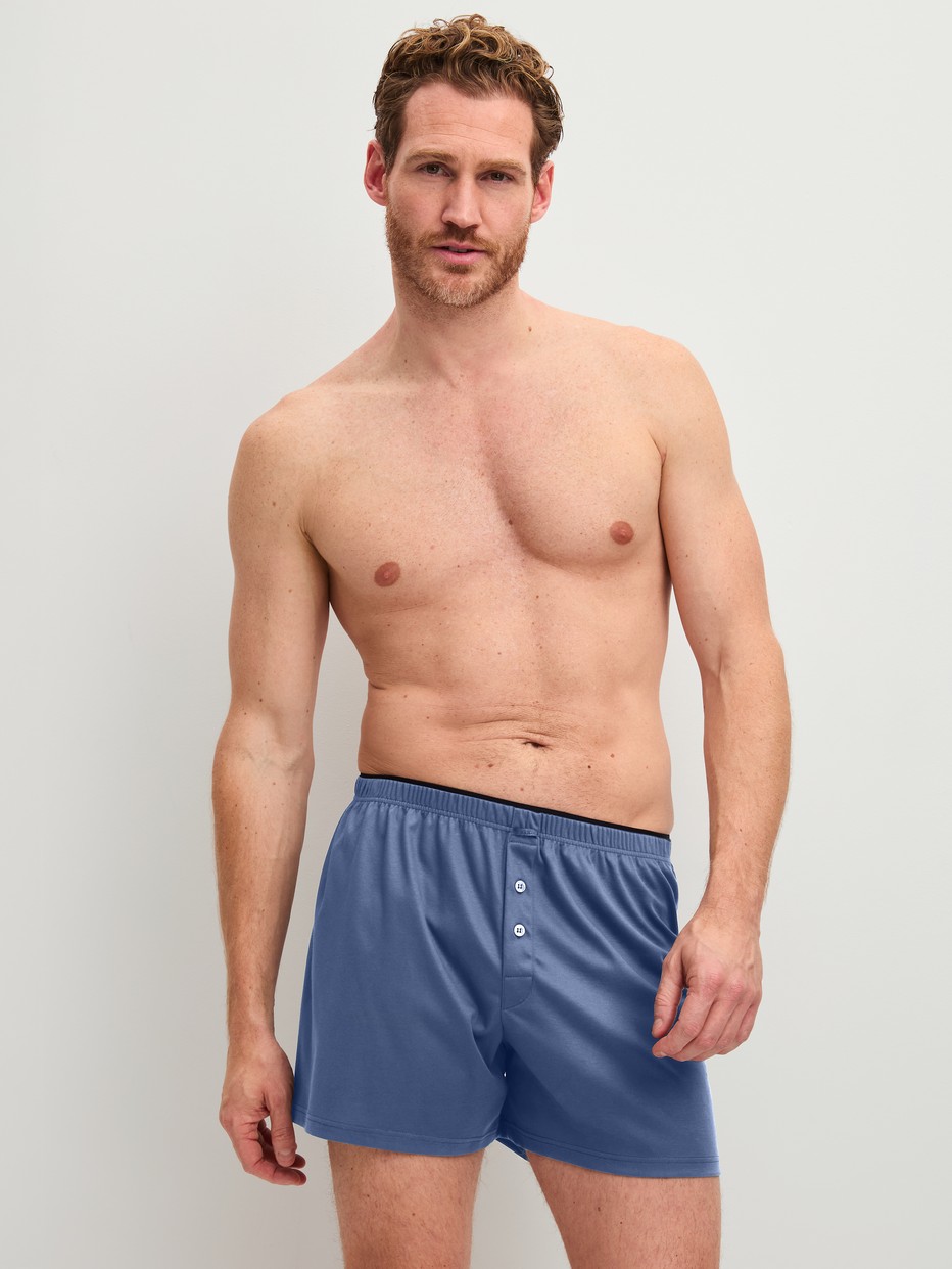 Herren-Model trägt Boxershorts aus 100% Baumwolle in Blau, Einfarbig aus Serie Cotton Choice von CALIDA, Outfit