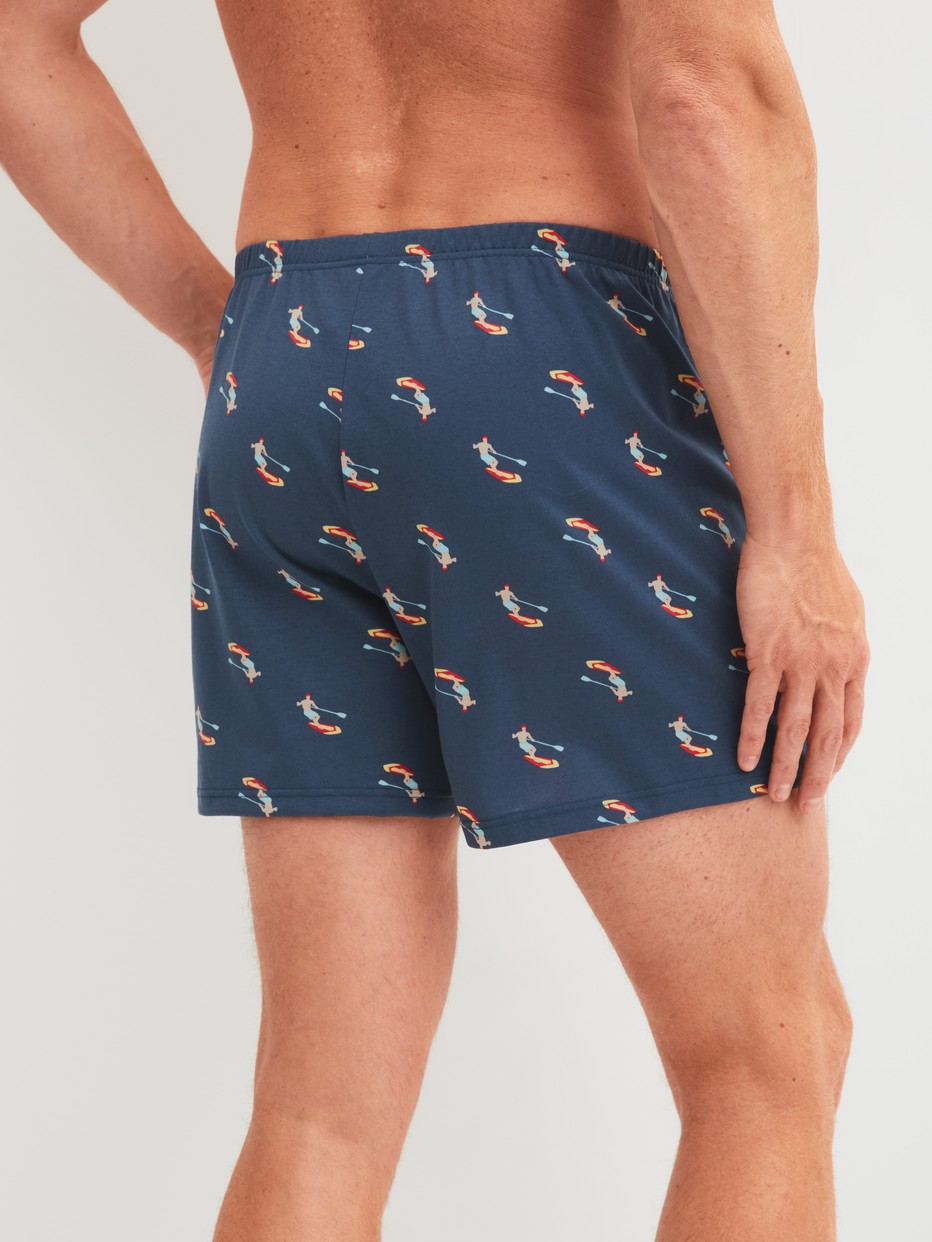 Men model is wearing Boxer shorts made of Cotton in Blue, Patterned from the Prints series by CALIDA, Back view