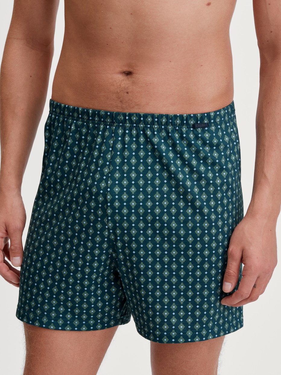 Herren-Model trägt Jersey-Boxershorts ohne Eingriff aus 100% Baumwolle in Türkis, Gemustert aus Serie Prints von CALIDA, Vorderansicht