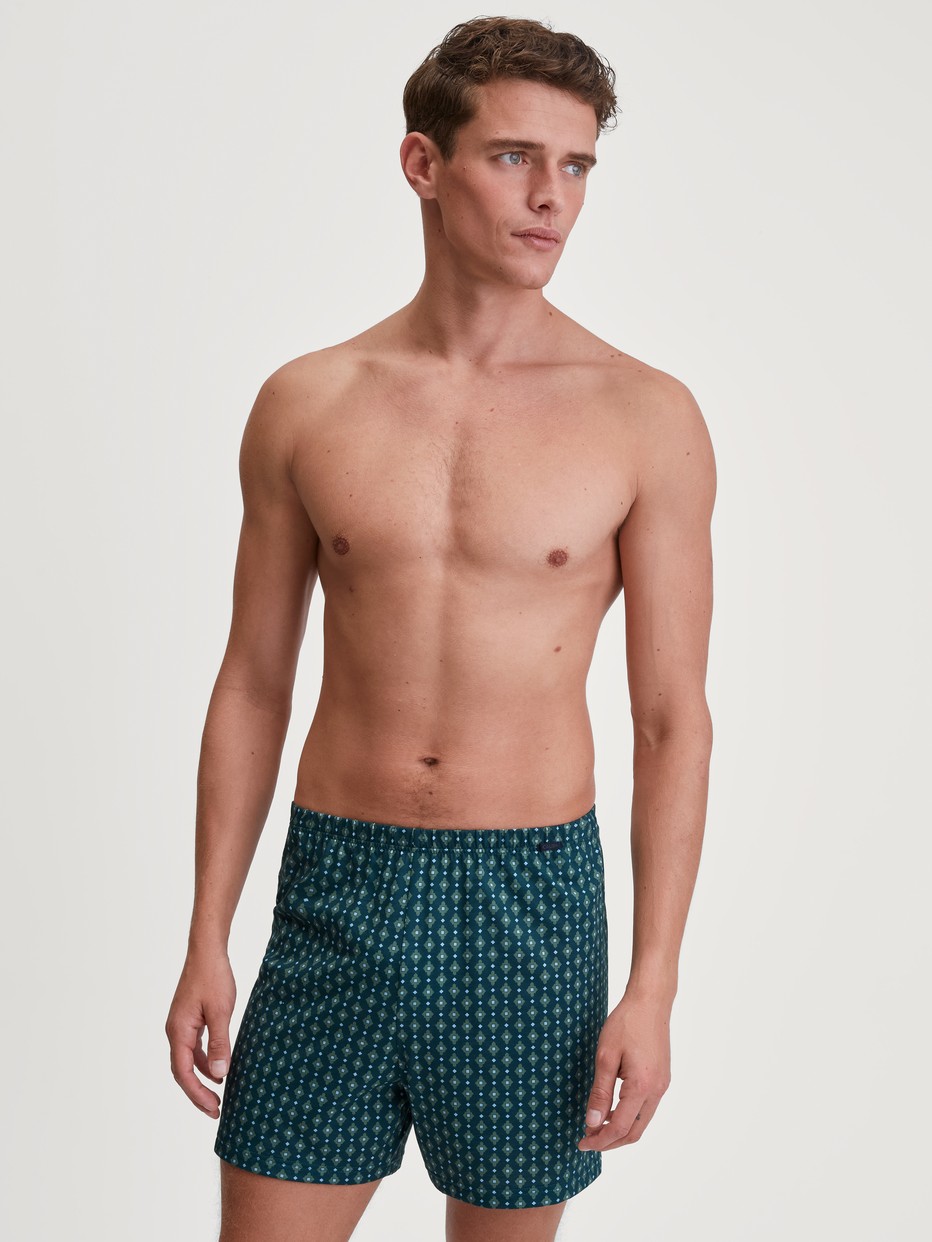 Herren-Model trägt Jersey-Boxershorts ohne Eingriff aus 100% Baumwolle in Türkis, Gemustert aus Serie Prints von CALIDA, Outfit