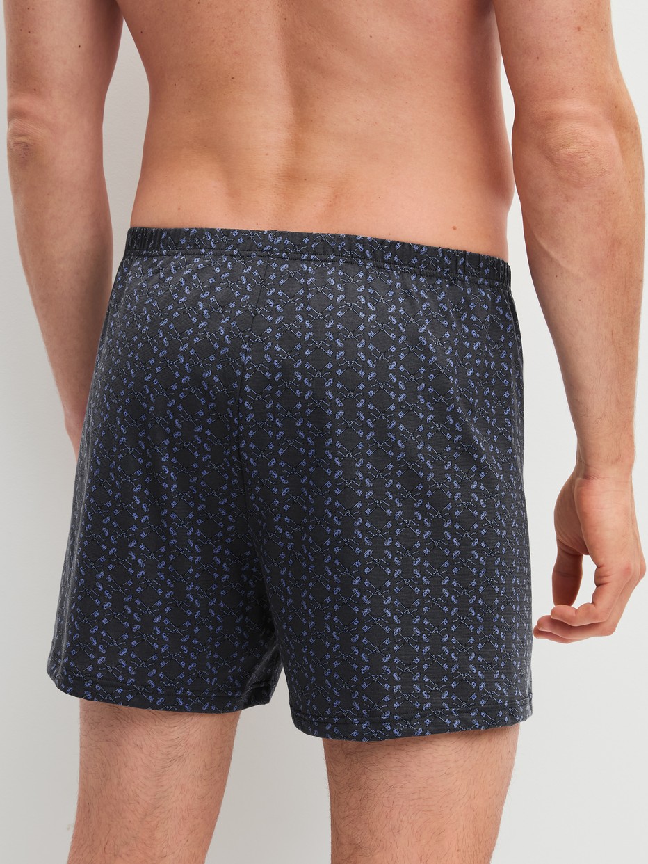 Herren-Model trägt Jersey-Boxershorts ohne Eingriff aus 100% Baumwolle in Grau, Gemustert aus Serie Prints von CALIDA, Rückansicht