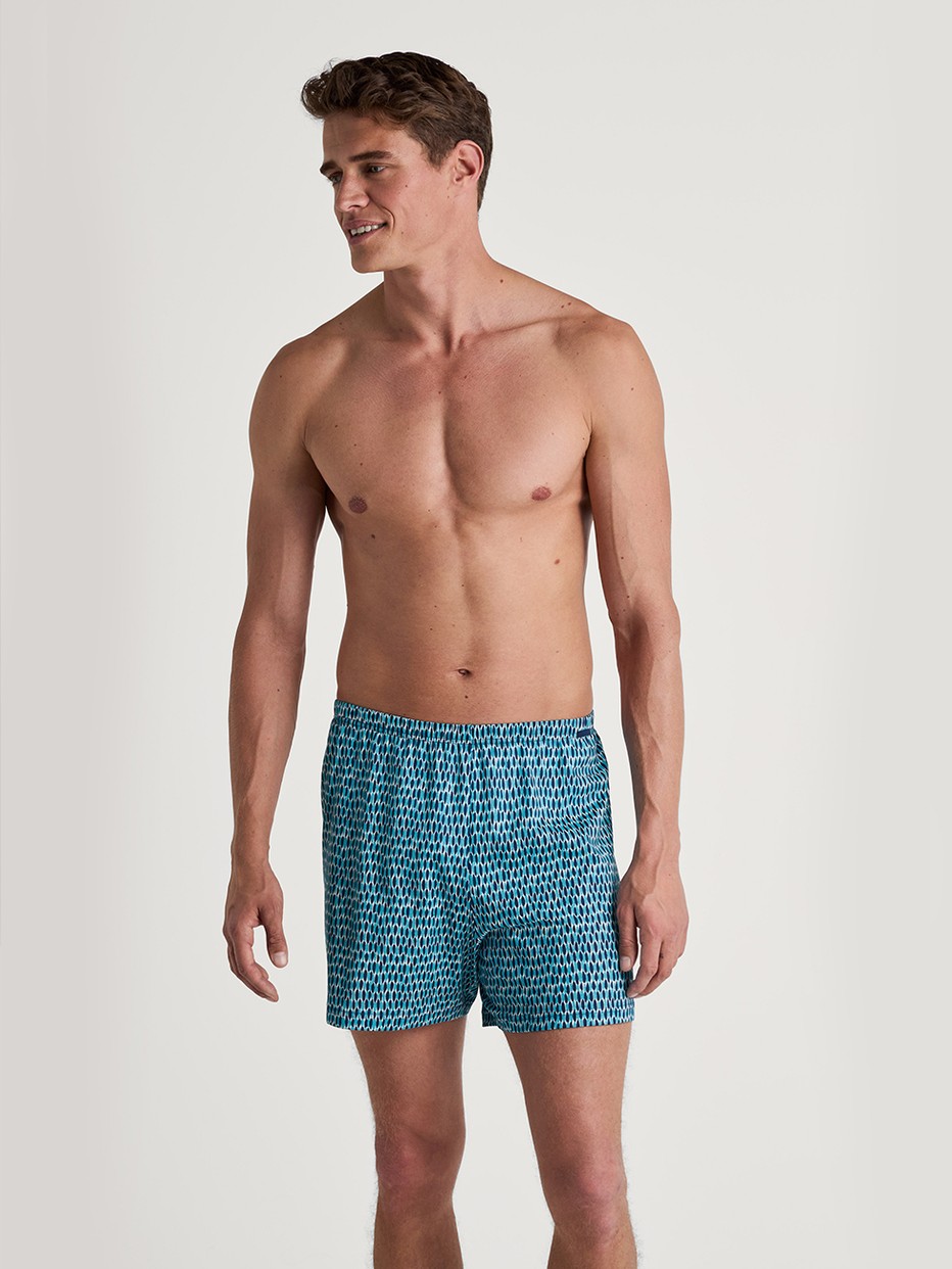 Herren-Model trägt Jersey-Boxershorts ohne Eingriff aus 100% Baumwolle in Türkis, Gemustert aus Serie Prints von CALIDA, Vorderansicht