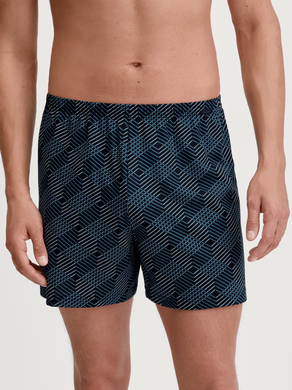 Le mannequin Homme porte le/la Boxer short en 100% coton de couleur Noir, À motifs, de la série Prints de CALIDA, Vue de face