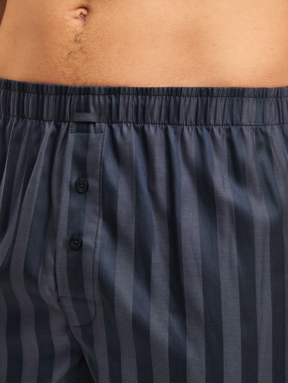 La modella / Il modello Uomo indossa Boxer short in Lyocell di colore Grigio, A righe, della serie Woven Lux di CALIDA, Dettaglio