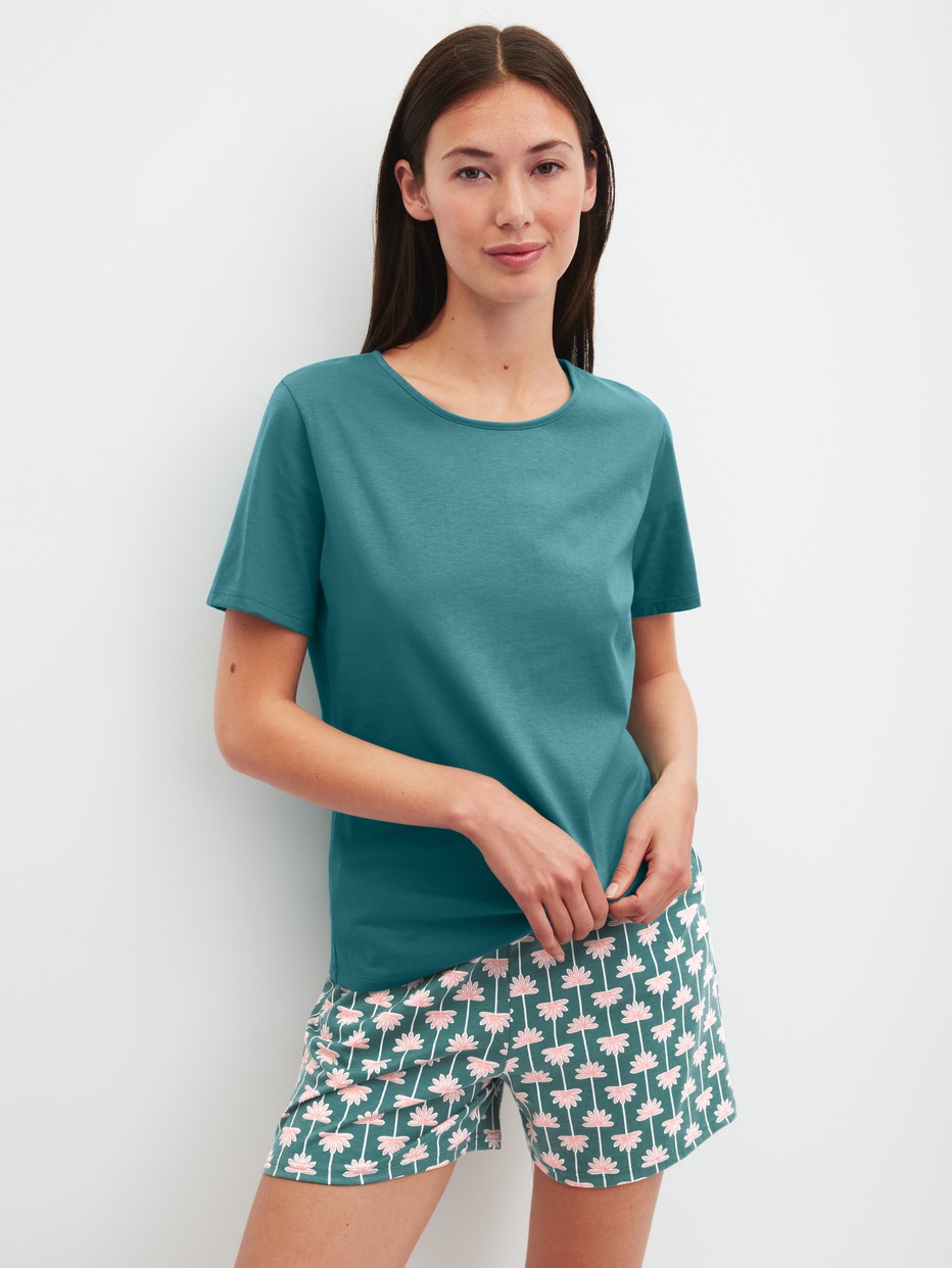 Damen-Model trägt Kurze Pyjamahose aus 100% Baumwolle in Türkis, Floral aus Serie Favourites Beach von CALIDA, Outfit