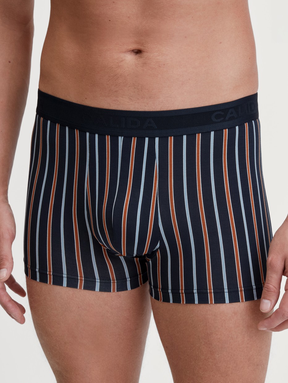 Herren-Model trägt Boxer Brief mit Softgummibund aus Baumwolle in Orange, Gemustert aus Serie Grafic Cotton von CALIDA, Vorderansicht