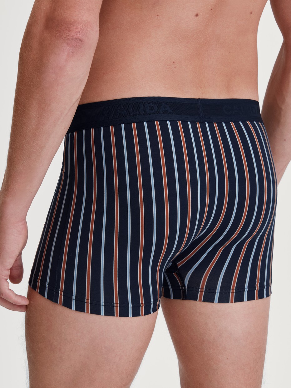 Herren-Model trägt Boxer Brief mit Softgummibund aus Baumwolle in Orange, Gemustert aus Serie Grafic Cotton von CALIDA, Rückansicht