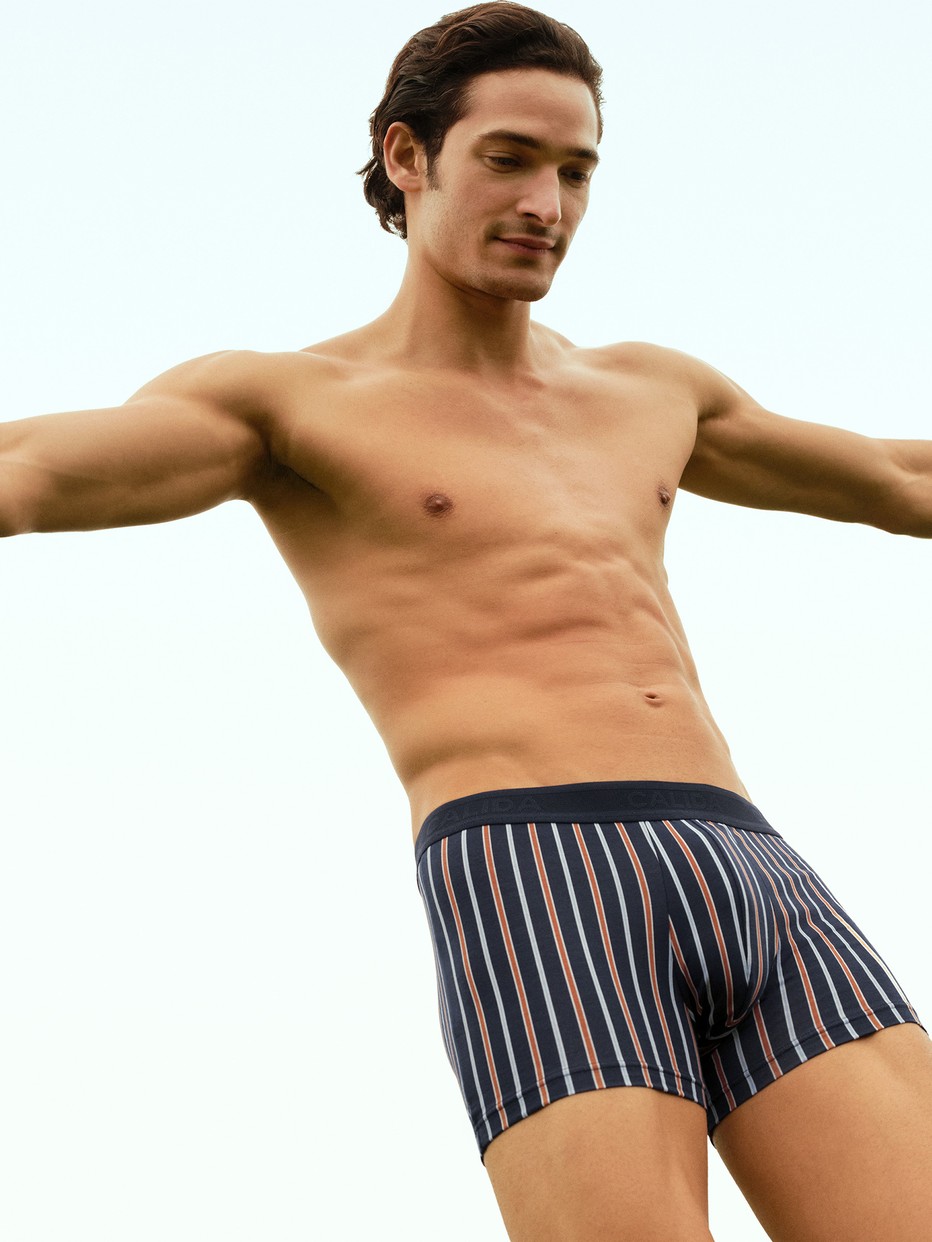 Herren-Model trägt Boxer Brief mit Softgummibund aus Baumwolle in Orange, Gemustert aus Serie Grafic Cotton von CALIDA, Vorderansicht