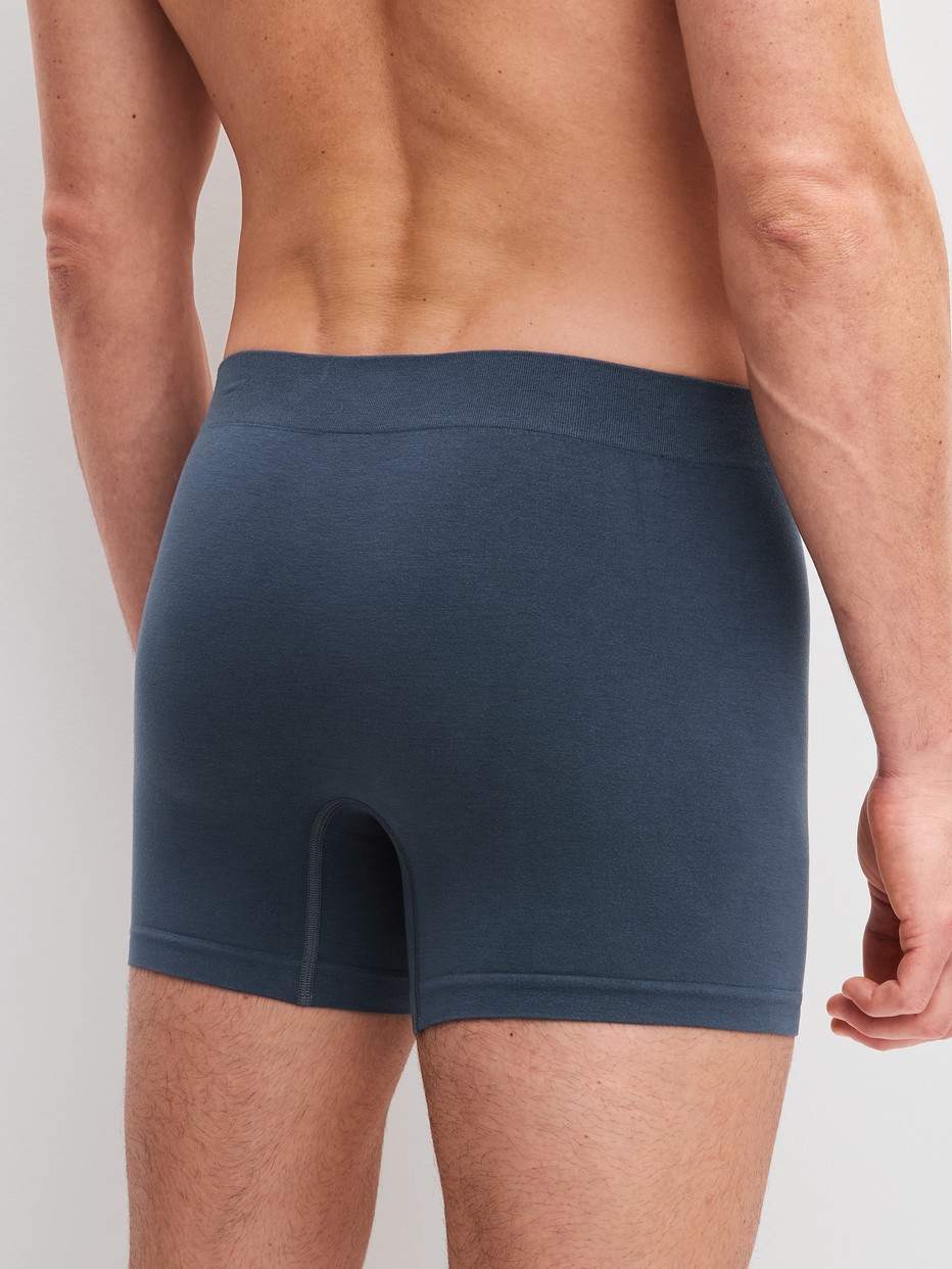 Herren-Model trägt Boxer Brief mit Softgummibund aus Modal in Grau, Einfarbig aus Serie Seamless Natural von CALIDA, Rückansicht