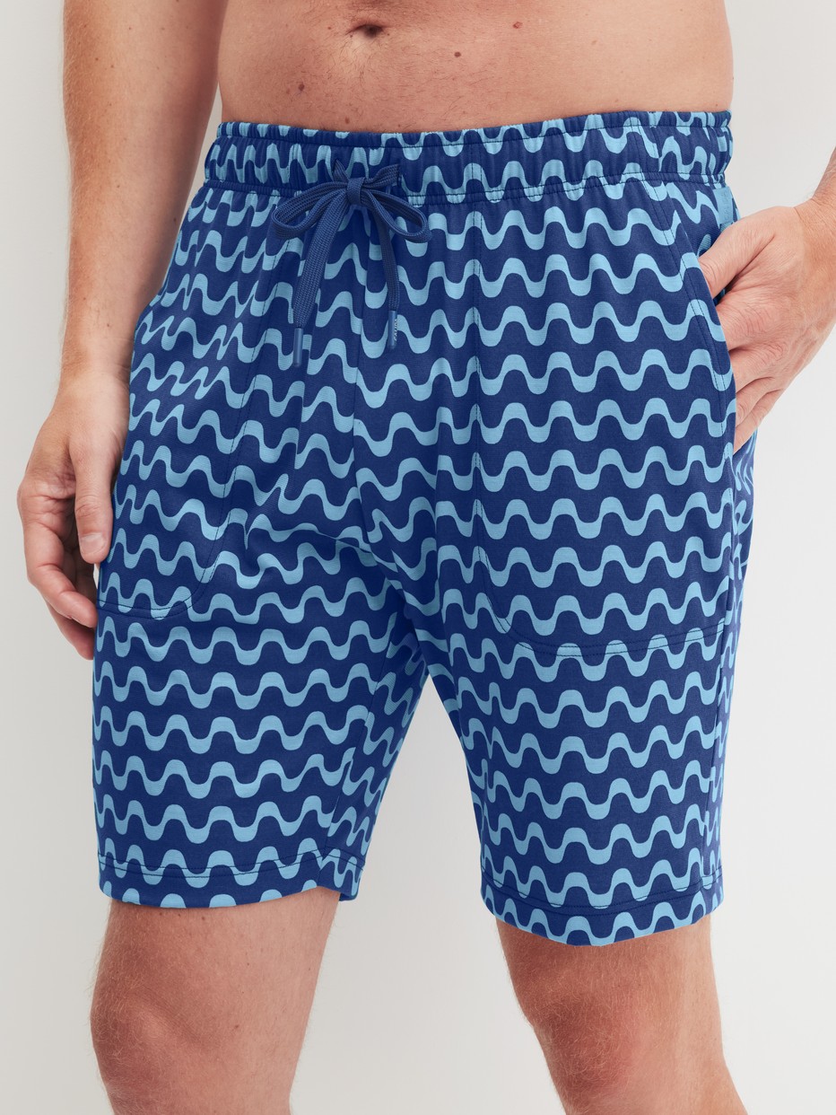 Men model is wearing Bermudas made of 100% Cotton in Blue, Patterned from the RMX Sleep Time off series by CALIDA, Front view