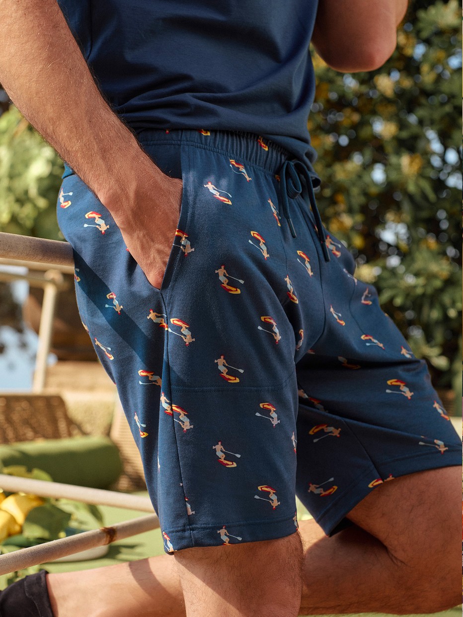 Men model is wearing Bermudas made of 100% Cotton in Blue, Patterned from the RMX Sleep Holiday series by CALIDA, Front View