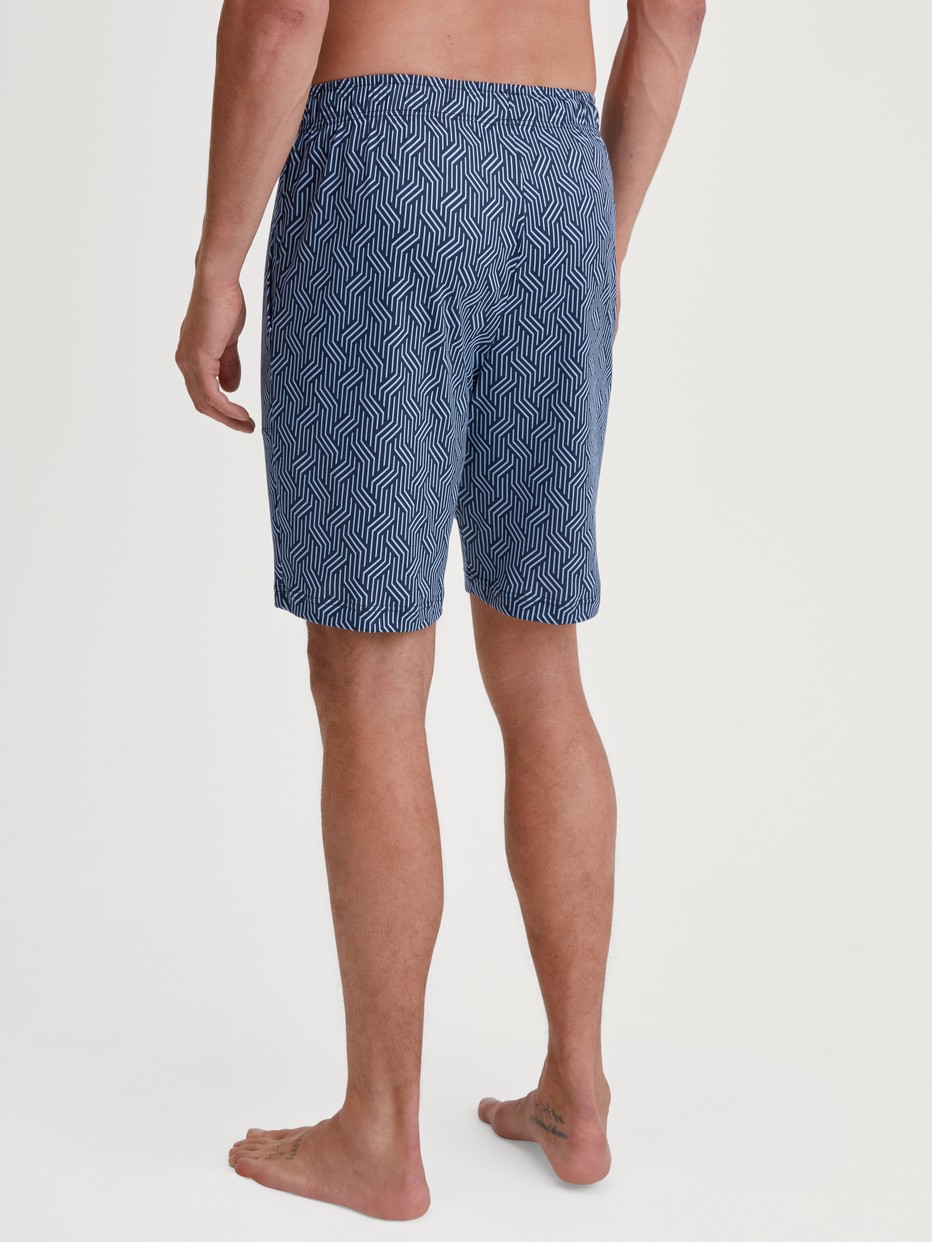 Men model is wearing Bermudas made of Cotton in Blue, Patterned from the RMX Sleep Free series by CALIDA, Back view