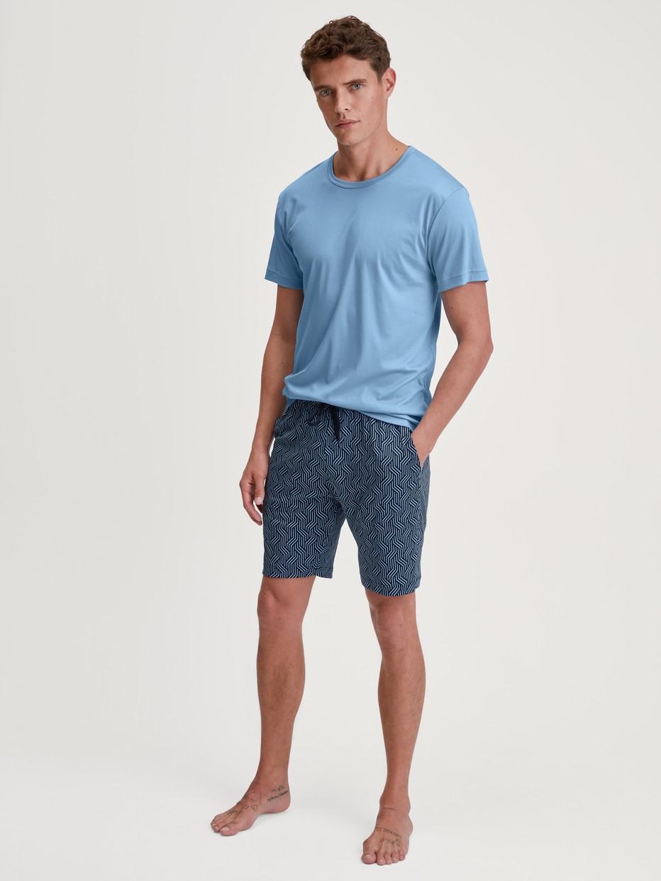 Men model is wearing Bermudas made of Cotton in Blue, Patterned from the RMX Sleep Free series by CALIDA, Outfit