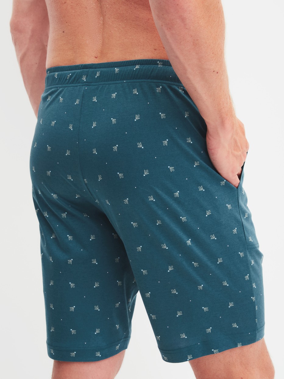 Herren-Model trägt Bermudas mit Seitentaschen aus Baumwolle in Türkis, Gemustert aus Serie RMX Sleep Free von CALIDA, Rückansicht