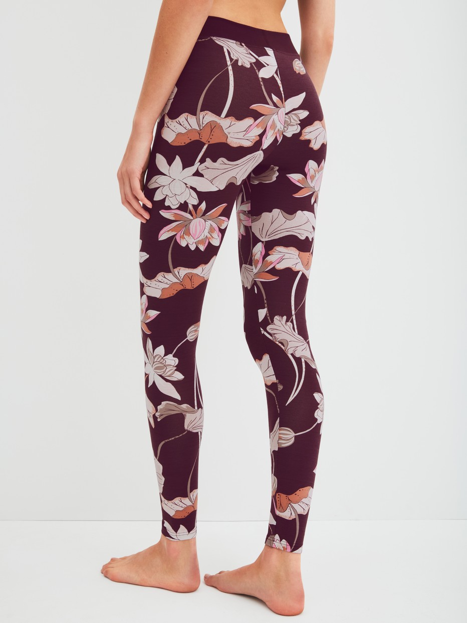 Damen-Model trägt Leggings mit Softbund aus Baumwolle in Rot, Floral aus Serie Elastic Trend Spec. von CALIDA, Rückansicht