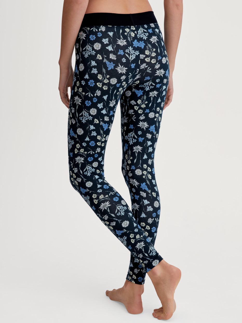 Damen-Model trägt Leggings mit Softbund aus Baumwolle in Schwarz, Floral aus Serie Elastic Trend von CALIDA, Rückansicht
