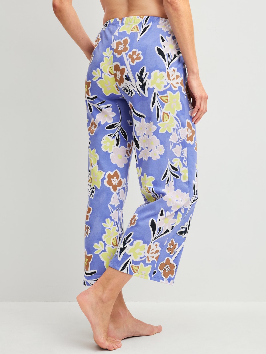 Damen-Model trägt 7/8-Pyjamahose aus 100% Baumwolle in Blau, Floral aus Serie Late Bloom M&M von CALIDA, Rückansicht