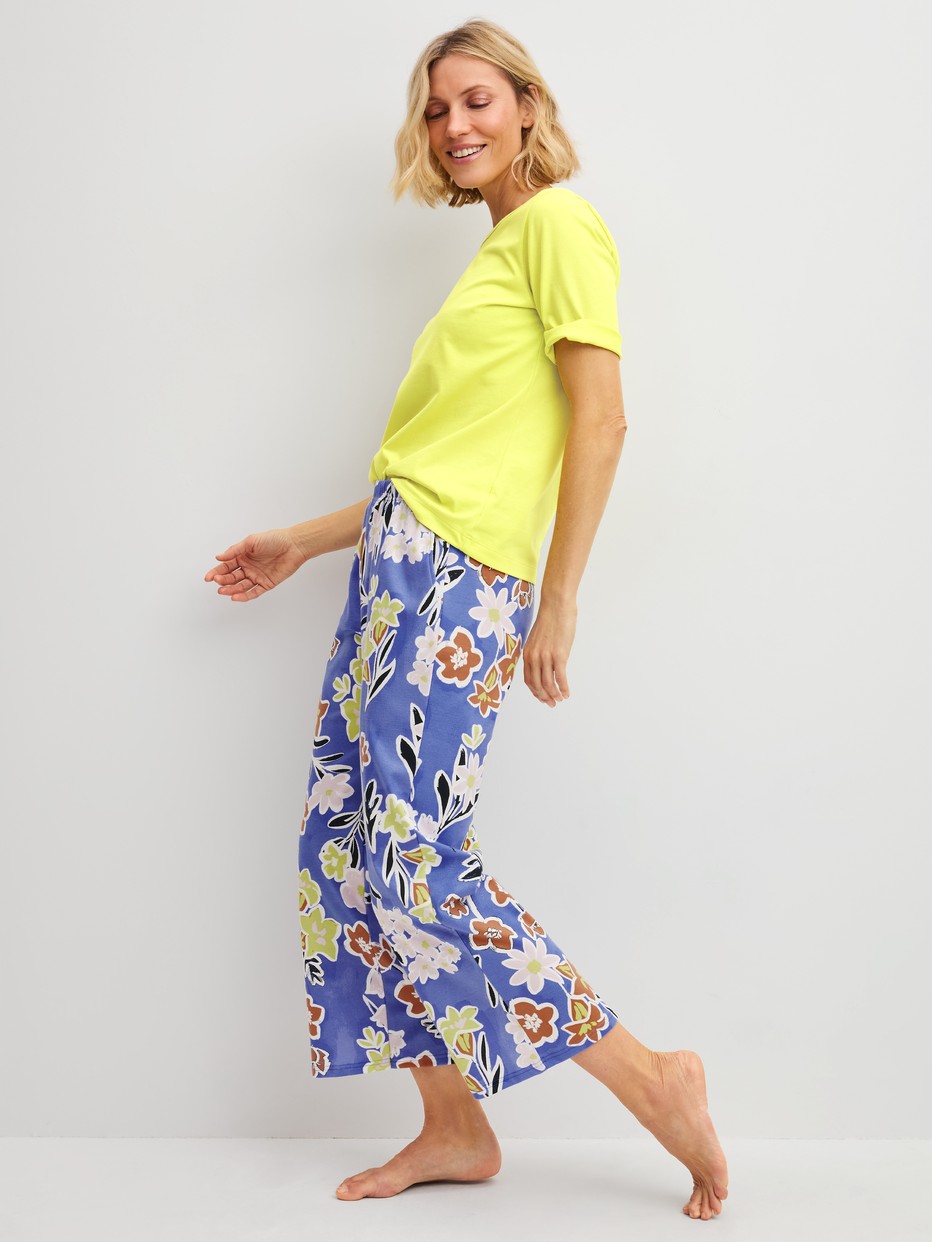 Damen-Model trägt 7/8-Pyjamahose aus 100% Baumwolle in Blau, Floral aus Serie Late Bloom M&M von CALIDA, Outfit