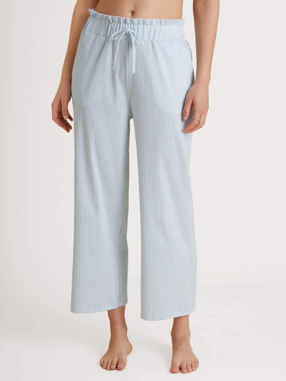 Women model is wearing 7/8 pants with paperbag waistband made of 100% Cotton in Blue, Striped from the Amalfi Journey series by CALIDA, Front view