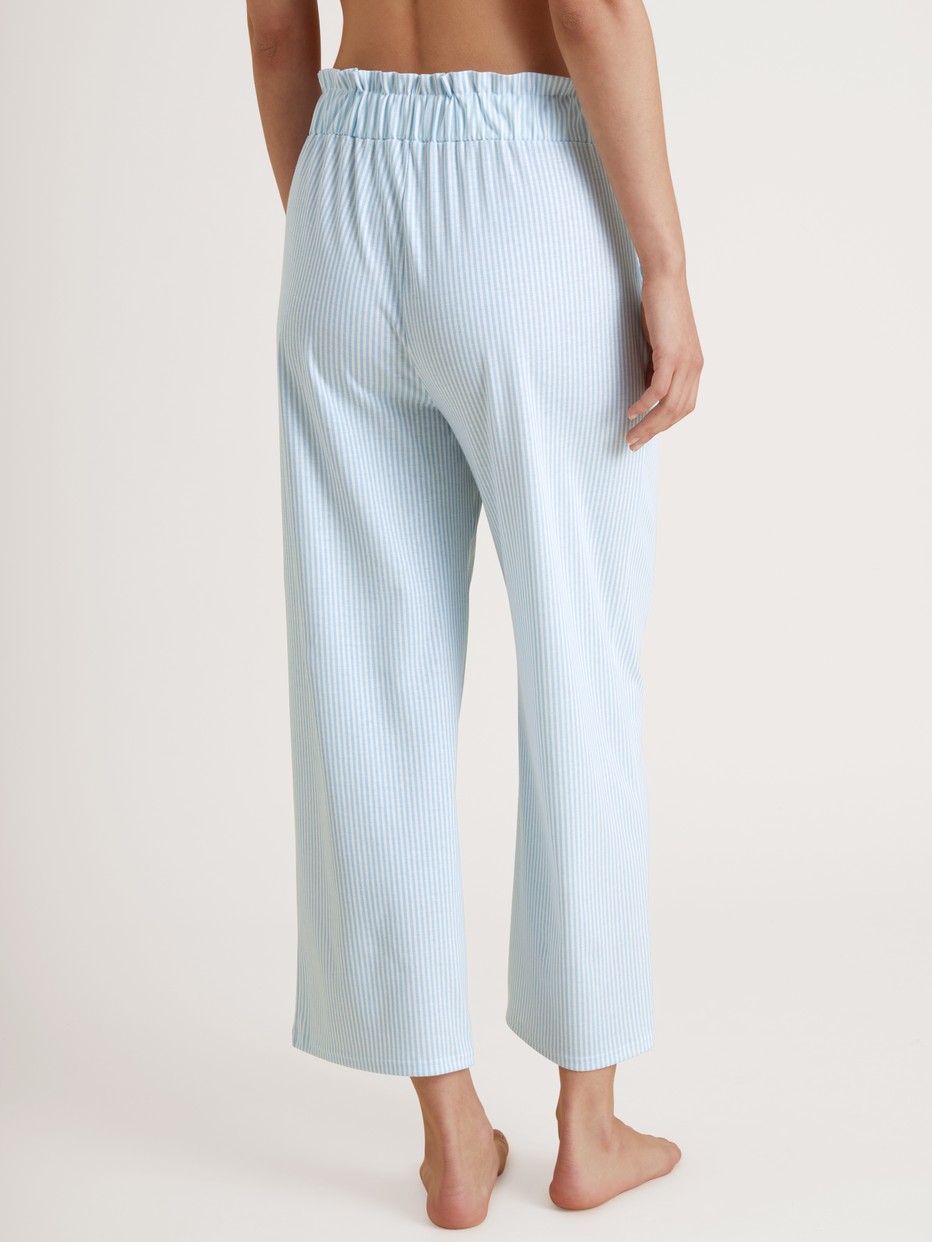 Women model is wearing 7/8 pants with paperbag waistband made of 100% Cotton in Blue, Striped from the Amalfi Journey series by CALIDA, Back view