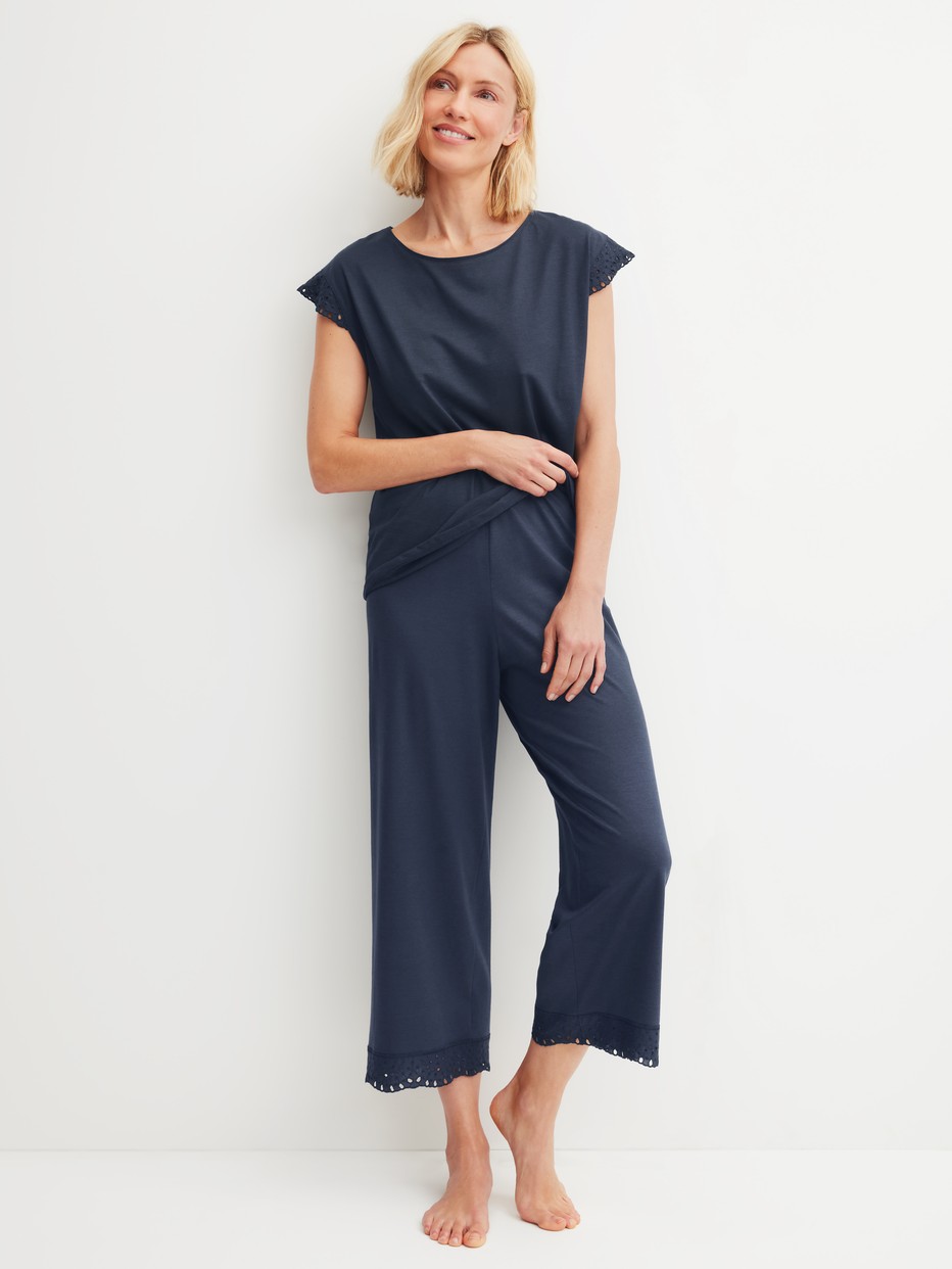 La modella / Il modello Donna indossa 7/8 Pantaloni pigiama in Cotone di colore Blu, Pizzo, della serie Favourites Tiles di CALIDA, Abbigliamento