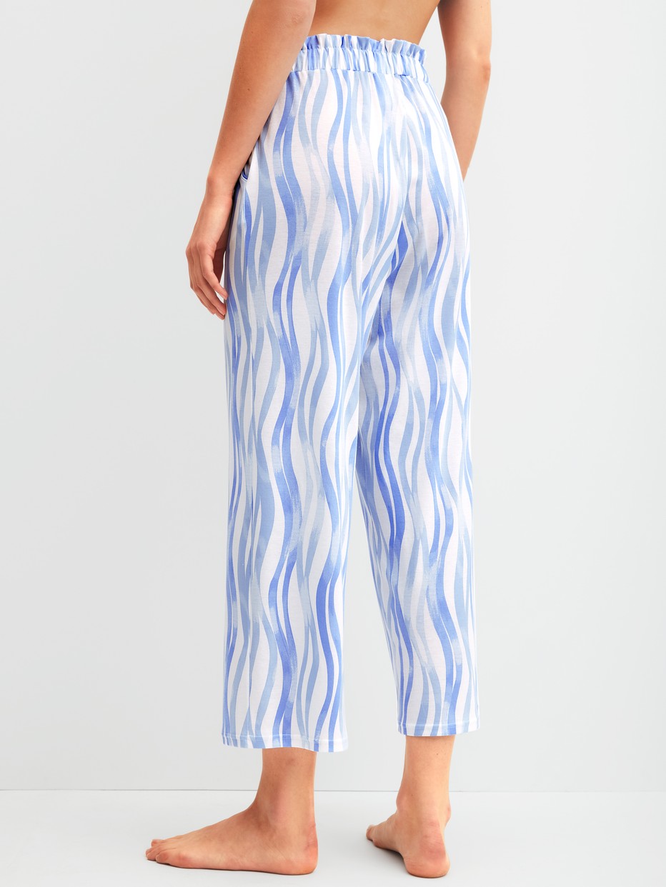 Women model is wearing 7/8 pyjama trousers made of Cotton in Blue, Patterned from the Favourites Ocean series by CALIDA, Back view
