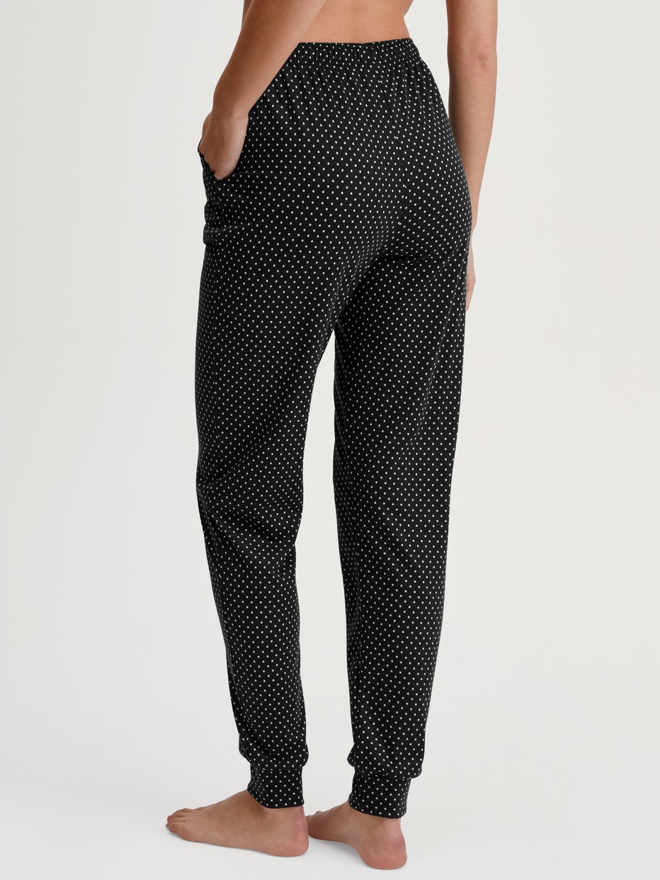 Damen-Model trägt Pyjamahose mit Bündchen aus Baumwolle in Schwarz, Einfarbig aus Serie Favourites Journey von CALIDA, Rückansicht