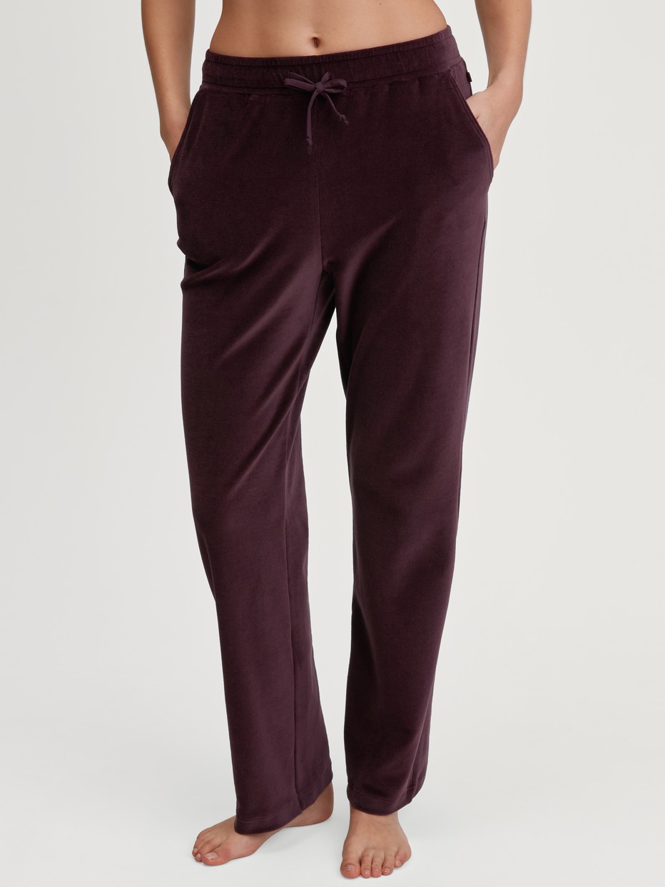 La modella / Il modello Donna indossa Pantaloni da casa in velluto in Cotone di colore Rosso, Tinta unita, della serie Lounge Velours di CALIDA, Vista frontale