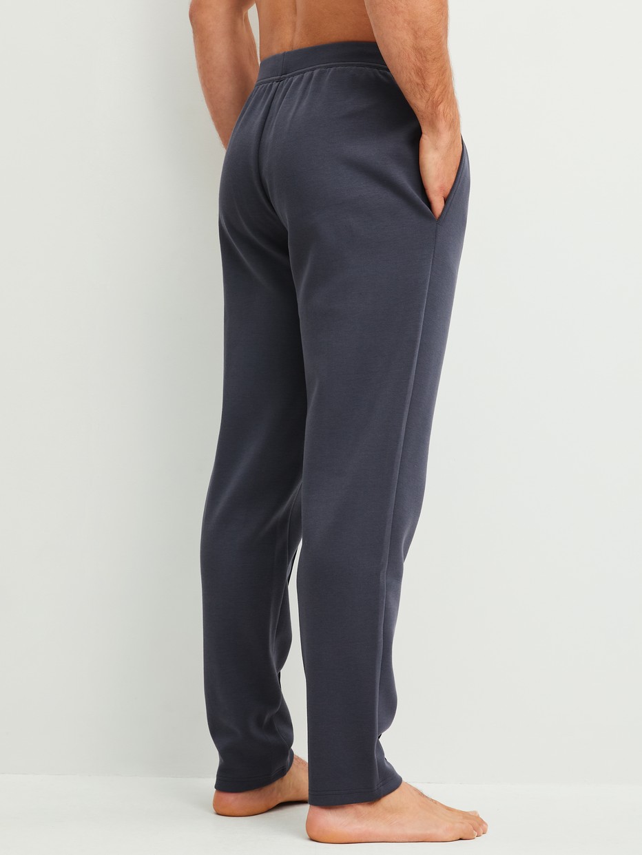 La modella / Il modello Uomo indossa Pantaloni da salotto in Cotone di colore Grigio, Tinta unita, della serie RMX Lounge Casual di CALIDA, Vista posteriore