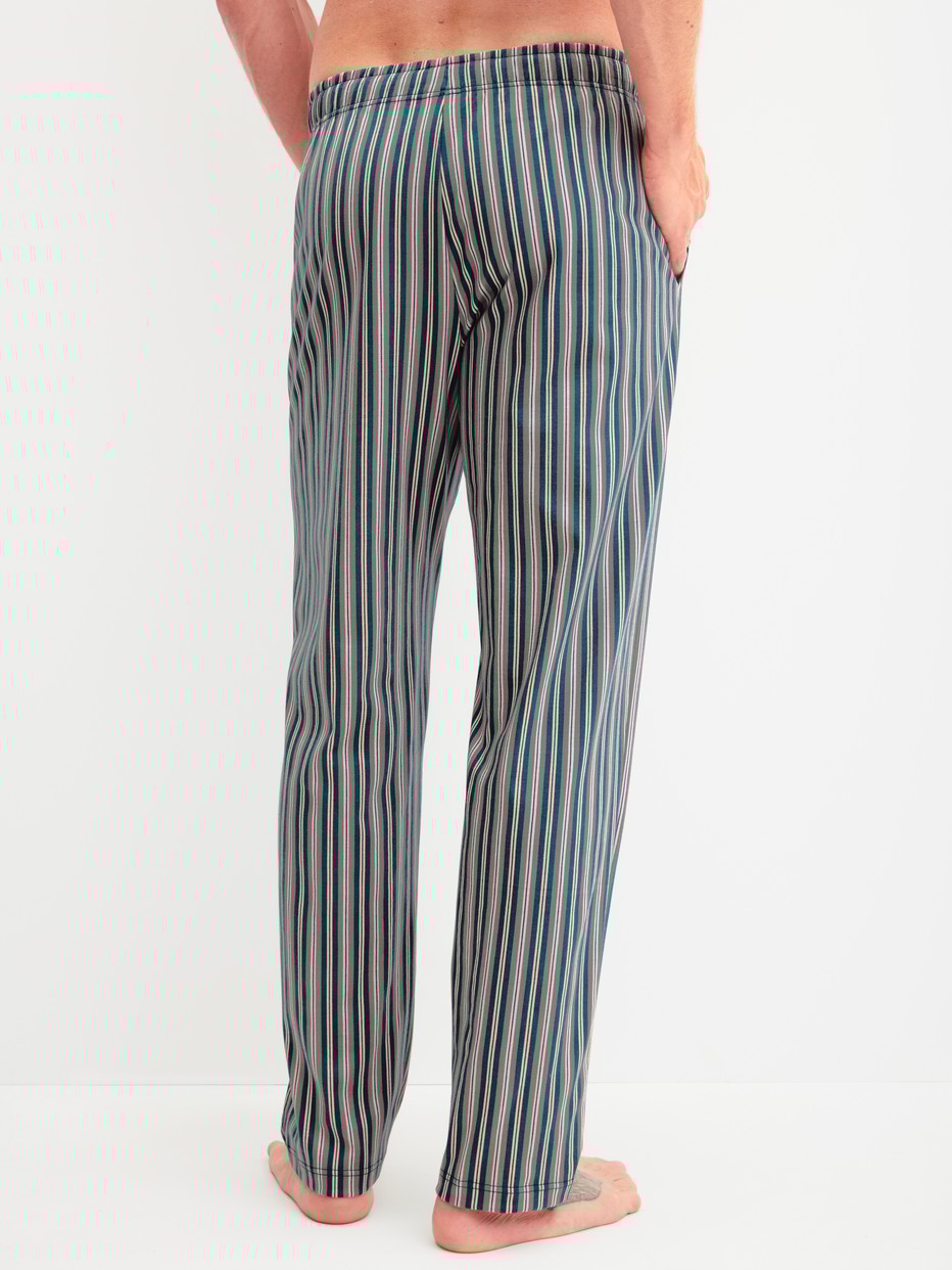 Herren-Model trägt Pyjamahose mit Seitentaschen aus 100% Baumwolle in Grün, Gestreift aus Serie RMX Sleep Leisure von CALIDA, Rückansicht