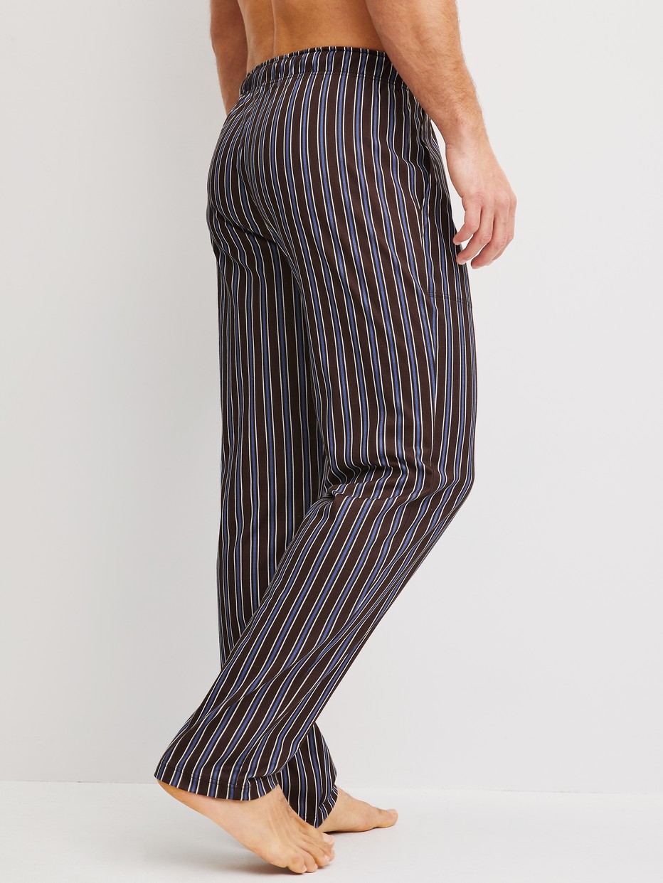 Men model is wearing Pyjama Bottoms with Side Pockets made of 100% Cotton in Brown, Striped from the RMX Sleep Weekend series by CALIDA, Back view