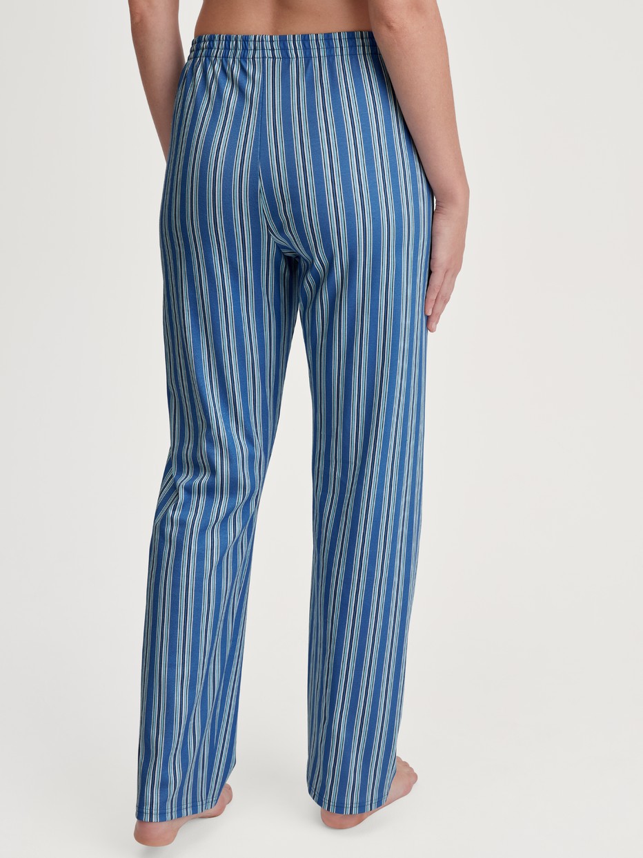Damen-Model trägt Pyjamahose aus 100% Baumwolle in Blau, Gestreift aus Serie Favourites Journey von CALIDA, Rückansicht
