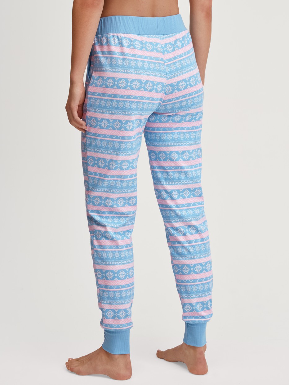 Women model is wearing Pyjama bottom with cuffs made of 100% Cotton in Blue, Patterned from the Ski Resort series by CALIDA, Back view