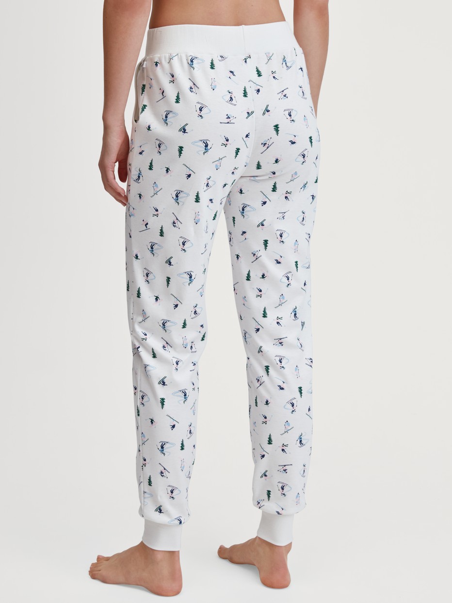 Women model is wearing Pyjama bottom with cuffs made of 100% Cotton in White, Patterned from the Ski Resort series by CALIDA, Back view