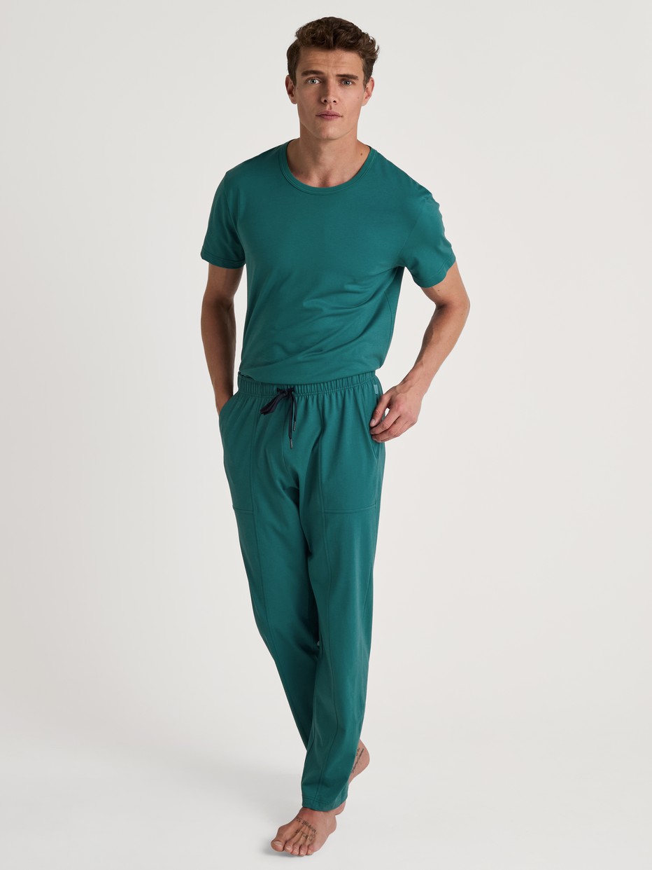 Le mannequin Homme porte le/la Bas de pyjama avec poches en 100% coton de couleur Vert, Unicolore, de la série RMX Sleep Weekend de CALIDA, Tenue