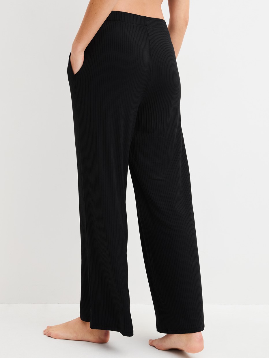 Damen-Model trägt Loungehose aus TENCEL™ Modal aus Modal in Schwarz, Einfarbig aus Serie Feminine Lounge von CALIDA, Rückansicht