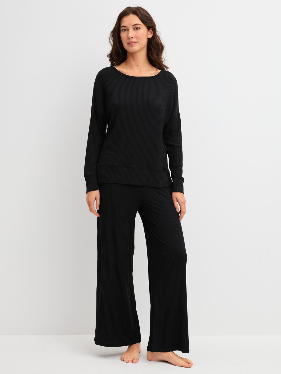 Damen-Model trägt Loungehose aus TENCEL™ Modal aus Modal in Schwarz, Einfarbig aus Serie Feminine Lounge von CALIDA, Outfit