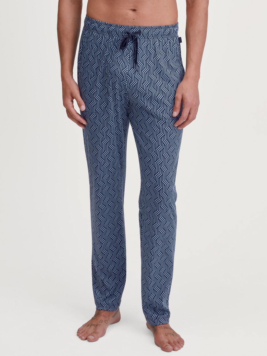 Men model is wearing Pyjama Bottoms with Side Pockets made of Cotton in Blue, Patterned from the RMX Sleep Free series by CALIDA, Front view