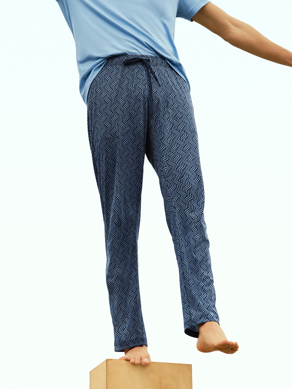 Men model is wearing Pyjama Bottoms with Side Pockets made of Cotton in Blue, Patterned from the RMX Sleep Free series by CALIDA, Front view