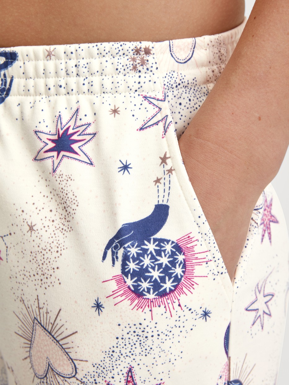 Damen-Model trägt Pyjamahose mit Seitentaschen aus 100% Baumwolle in Beige, Gemustert aus Serie Favourites Universe von CALIDA, Detail