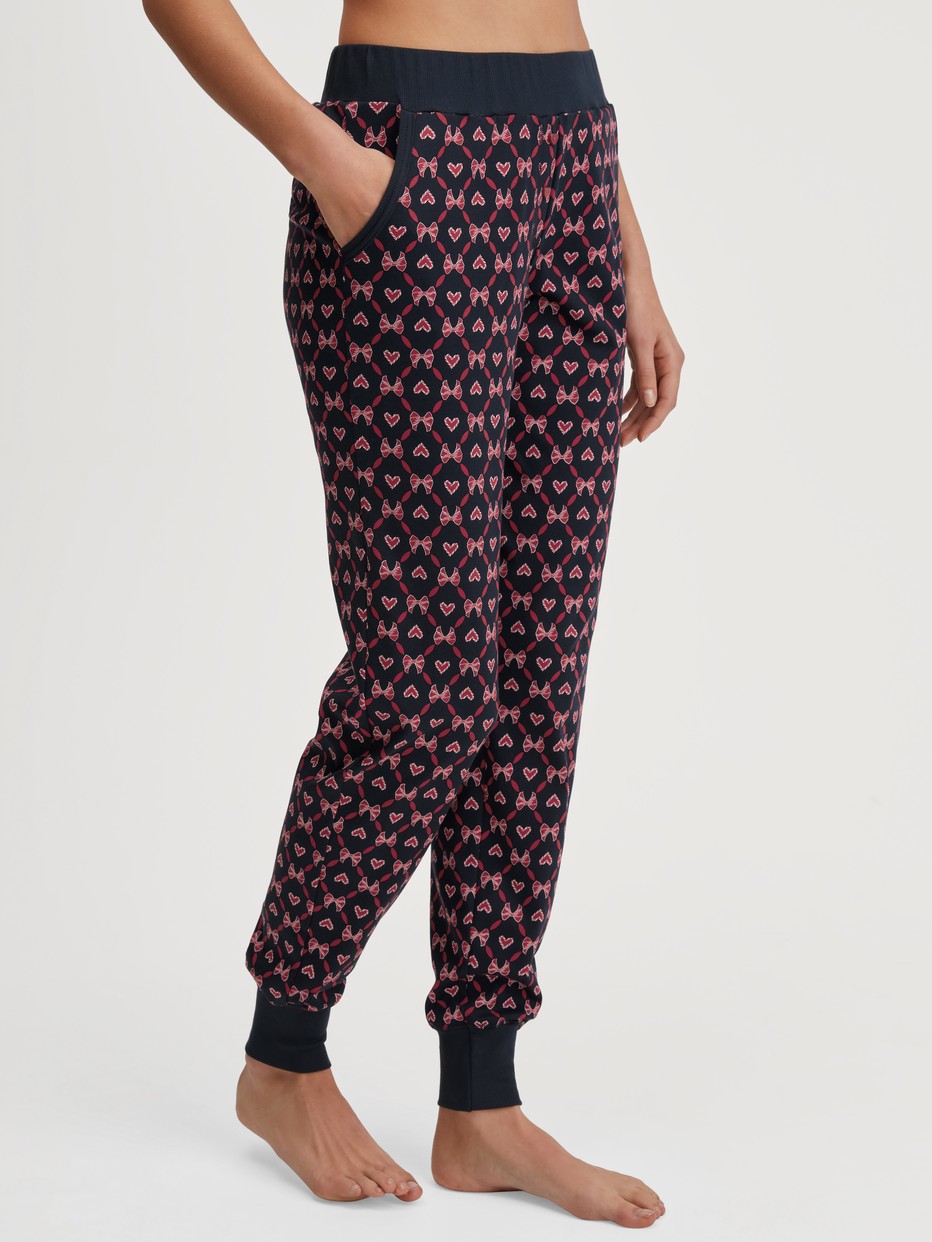 Women model is wearing Pyjama trousers with cuffs and side pockets made of 100% Cotton in Blue, Patterned from the Favourites Holidays series by CALIDA, Front view