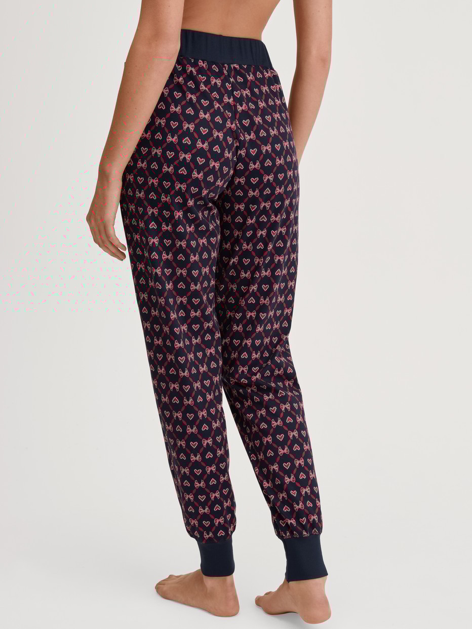 Women model is wearing Pyjama trousers with cuffs and side pockets made of 100% Cotton in Blue, Patterned from the Favourites Holidays series by CALIDA, Back view