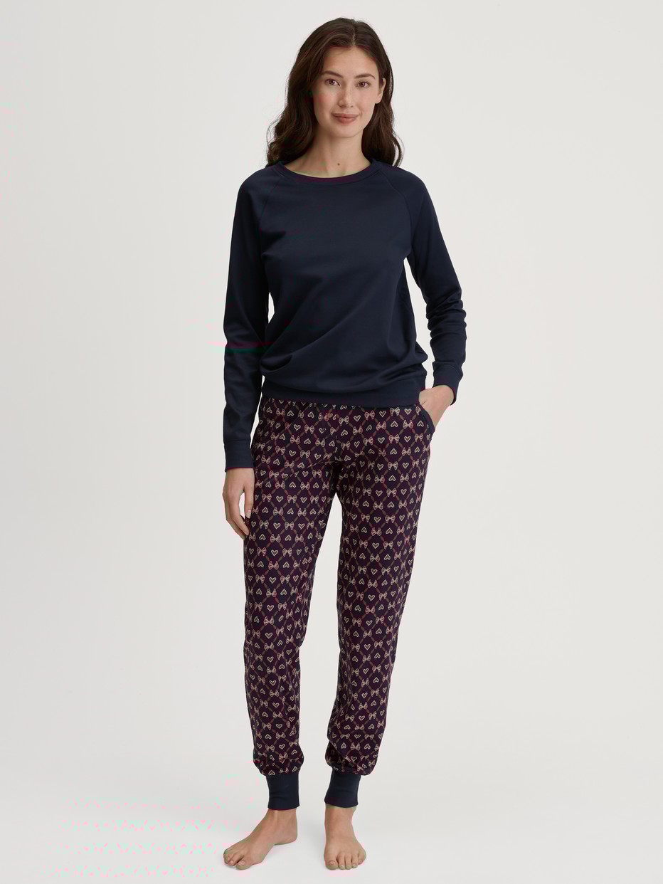 Women model is wearing Pyjama trousers with cuffs and side pockets made of 100% Cotton in Blue, Patterned from the Favourites Holidays series by CALIDA, Outfit