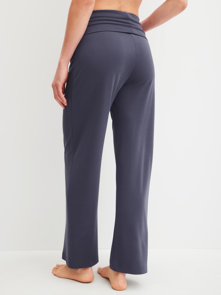 Damen-Model trägt Pyjamahose aus Modal in Blau, Einfarbig aus Serie Natural Loungewear von CALIDA, Rückansicht