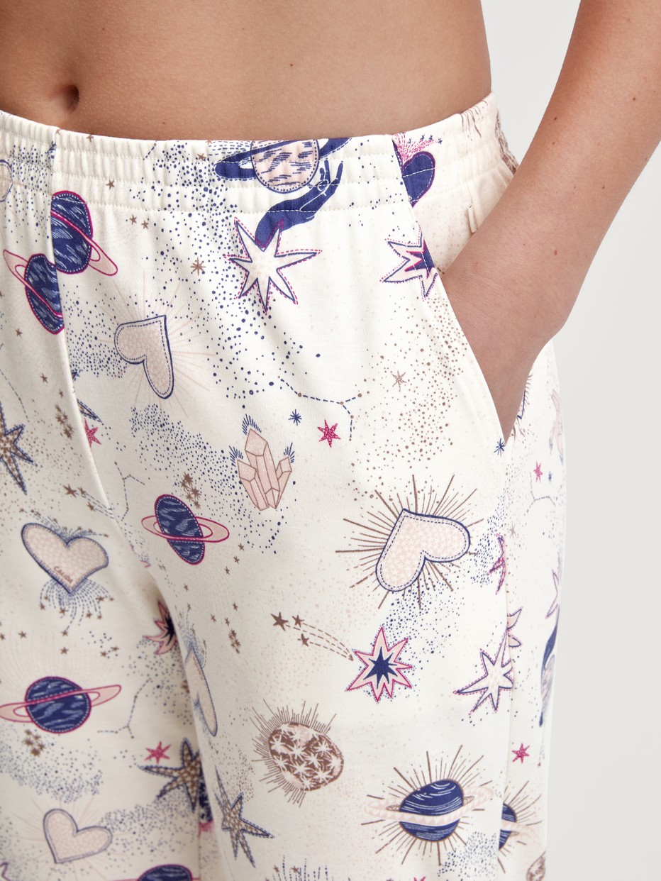 Damen-Model trägt Pyjamahose mit Bündchen aus 100% Baumwolle in Beige, Gemustert aus Serie Favourites Universe von CALIDA, Detail