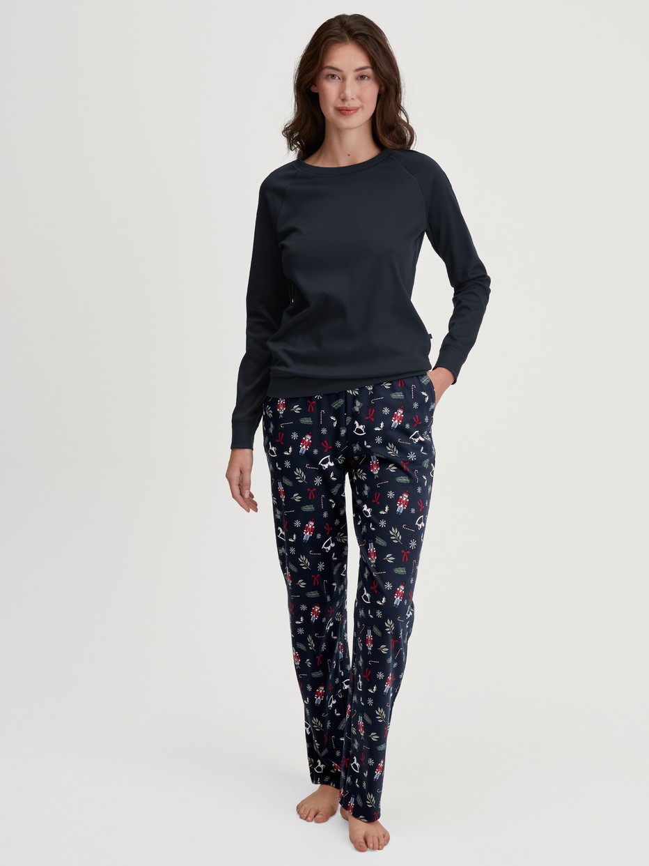 Damen-Model trägt Pyjamahose mit Seitentaschen aus 100% Baumwolle in Blau, Gemustert aus Serie Favourites Holidays von CALIDA, Outfit