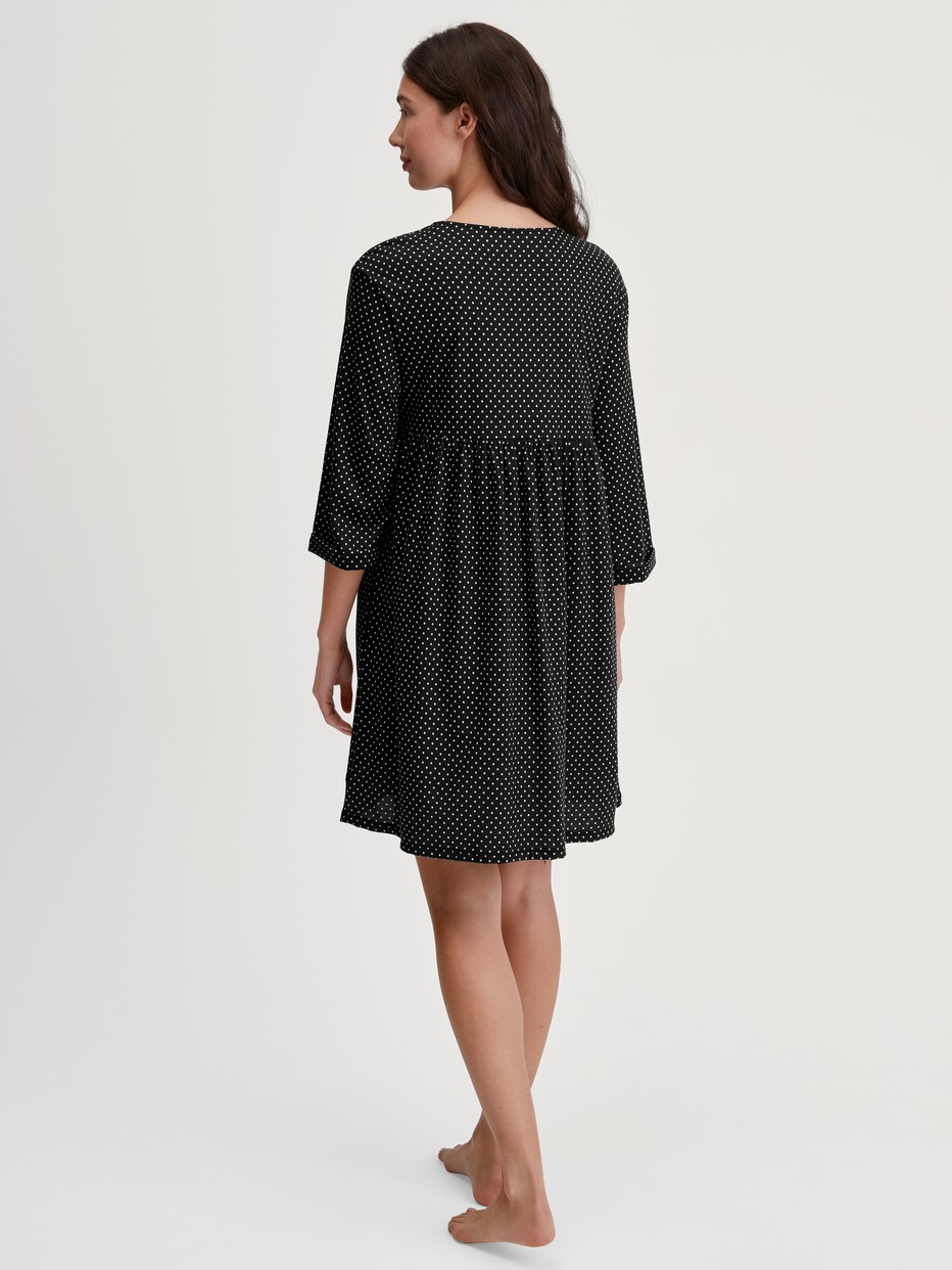 Damen-Model trägt Hauskleid, Länge 90 cm aus Baumwolle in Schwarz, Einfarbig aus Serie Favourites Journey von CALIDA, Rückansicht