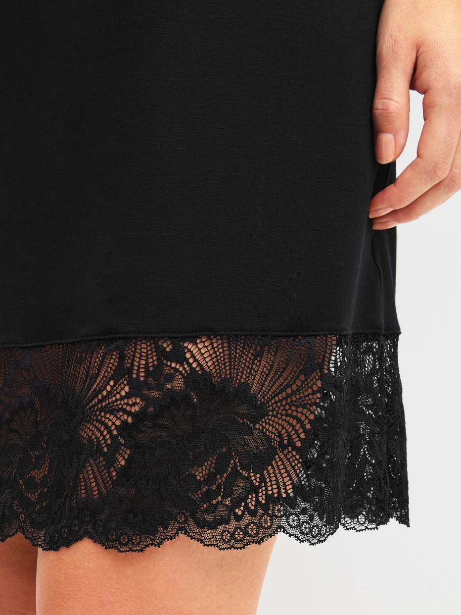 Le mannequin Femme porte le/la Chemise de nuit à manches courtes, longueur 95 cm en Modal de couleur Noir, Dentelle, de la série Elegant Dreams de CALIDA, Détail