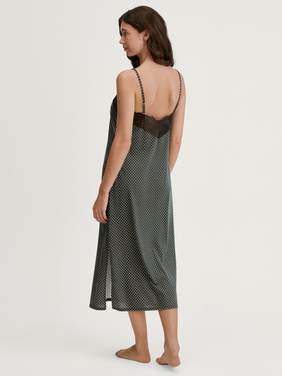 Damen-Model trägt Nachthemd mit Spaghettiträgern, Länge 125 cm aus Baumwolle in Schwarz, Spitze aus Serie Deep Dreams von CALIDA, Rückansicht
