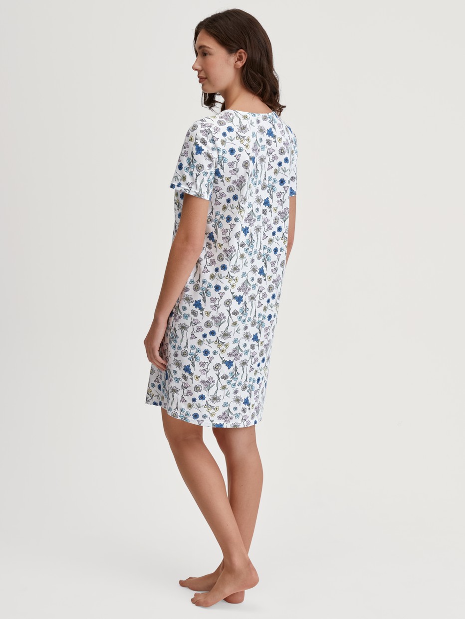 Damen-Model trägt Kurzarm-Nachthemd, Länge 90 cm aus 100% Baumwolle in Blau, Floral aus Serie Flower Nights von CALIDA, Rückansicht